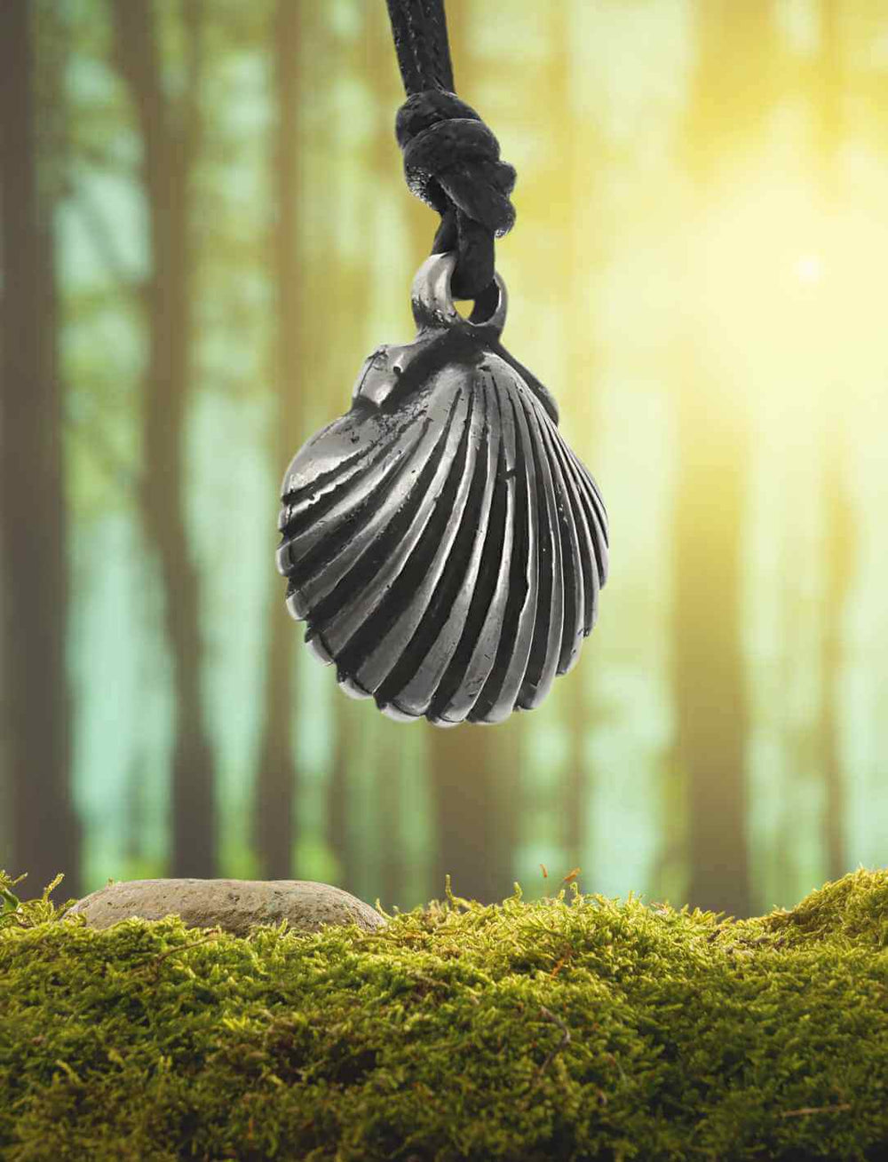 akobsmuschel-Amulett des Jakobswegs – mittelalterliches Pilgersymbol, inszeniert vor mystischem Waldhintergrund.
