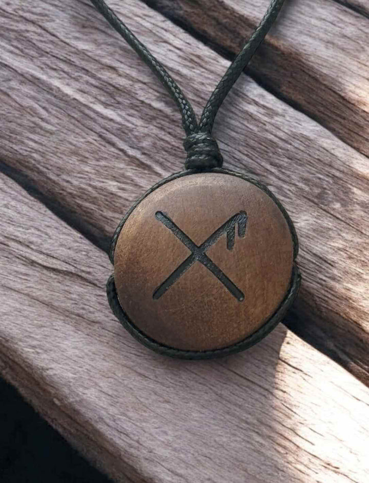 Binderune für Glück, rundes Holz-Amulett mit Rune, auf hellem Holz fotografiert