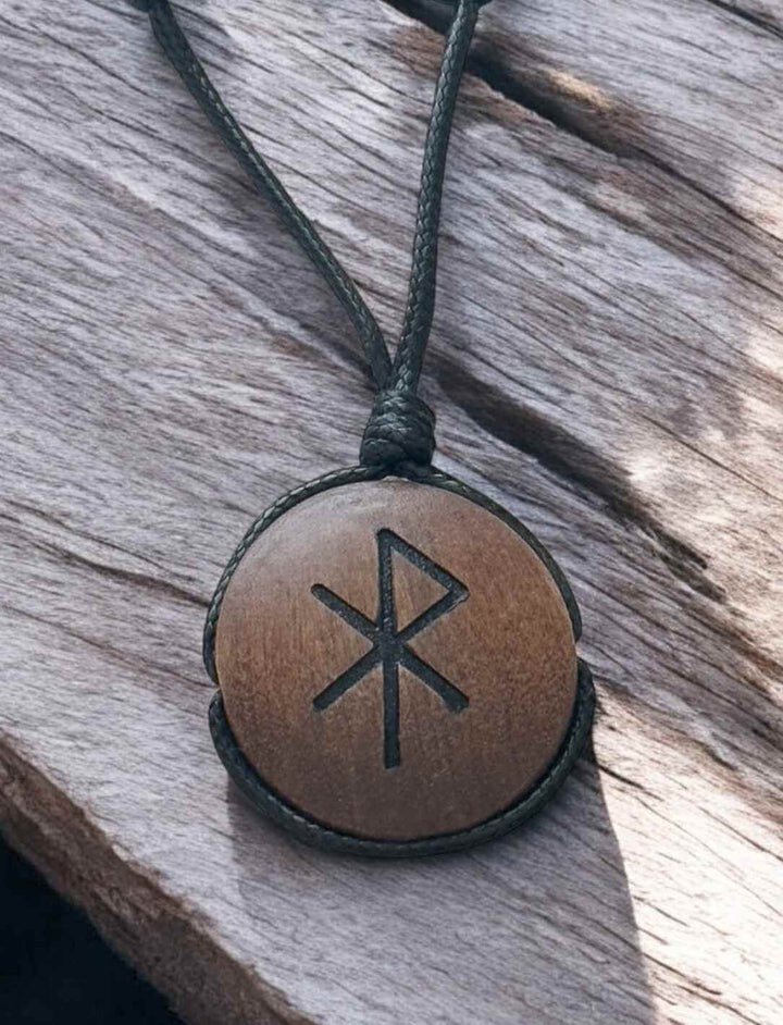 Binderune für Liebe, Holz-Amulett mit eingraviertem Symbol, Nahaufnahme auf Holz