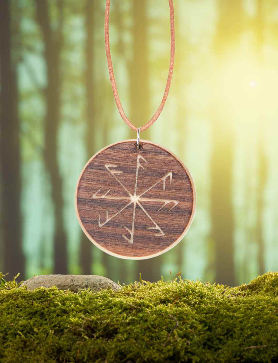 Ansenknecht Amulett aus Ahorn- und Nussbaumholz auf natürlichem Moos/Wald-Hintergrund.