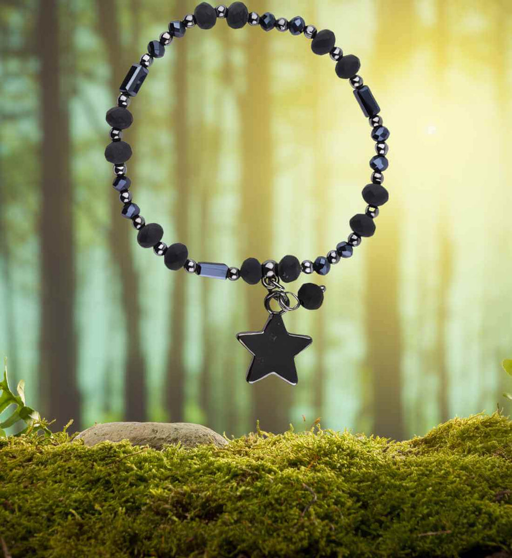 Armband des Dunkelsterns - Eingebettet in die natürliche Umgebung eines Moos-Wald-Hintergrunds, ruft es Bilder alter Wälder und Sternenmythen hervor.