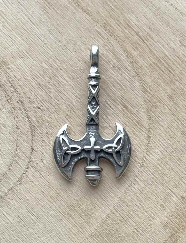 Edelstahl-Anhänger „Axt des Sonnenkreuzes“ an Lederband, fotografiert auf Holz.