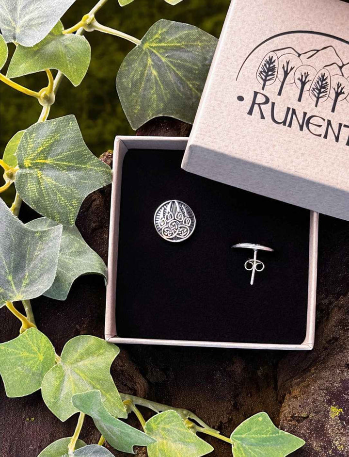 Bärentatze des Druiden – silberner Ohrstecker mit keltischem Tatzenmotiv in Runental Geschenkbox auf Baumstumpf mit Efeu fotografiert.