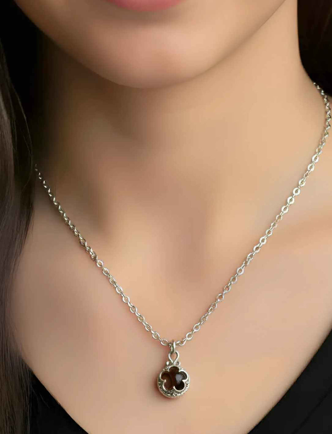 Model trägt die Blüte von Gotland – Silberanhänger mit dunkelbraunem Tigerauge an Anker Silberkette.