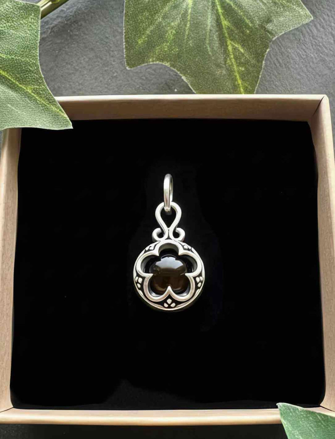 Blüte von Gotland – Silberamulett, feine Ornamentgravur mit dunkelbraunem Tigerauge, in Geschenkbox.