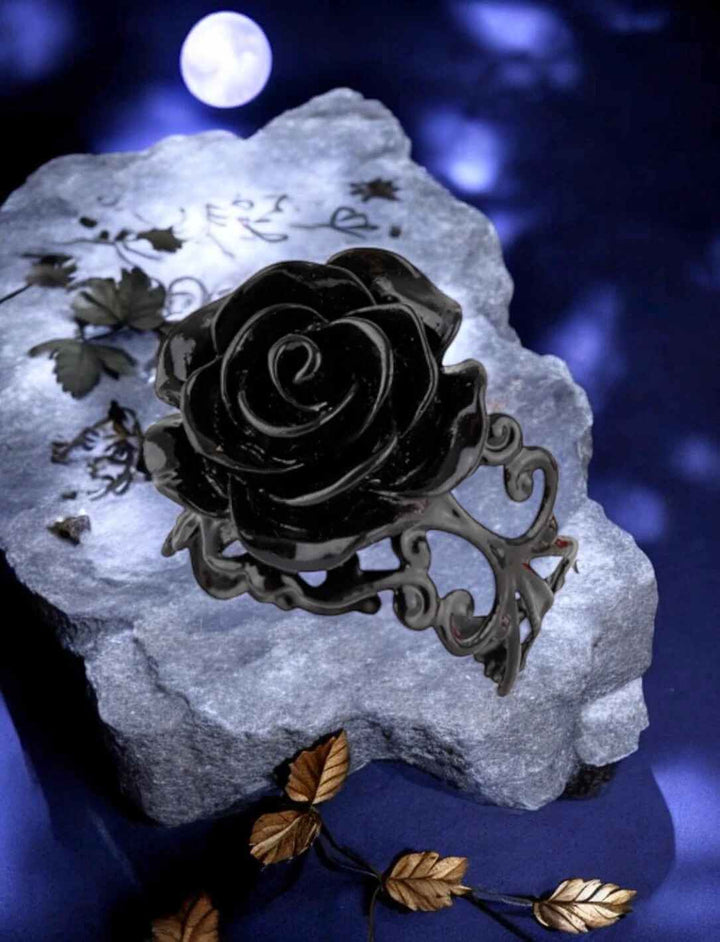 Mystischer schwarzer Rosenring auf Stein unter Mondlicht – Fantasy-Schmuck auf Felsen mit goldenen Blättern