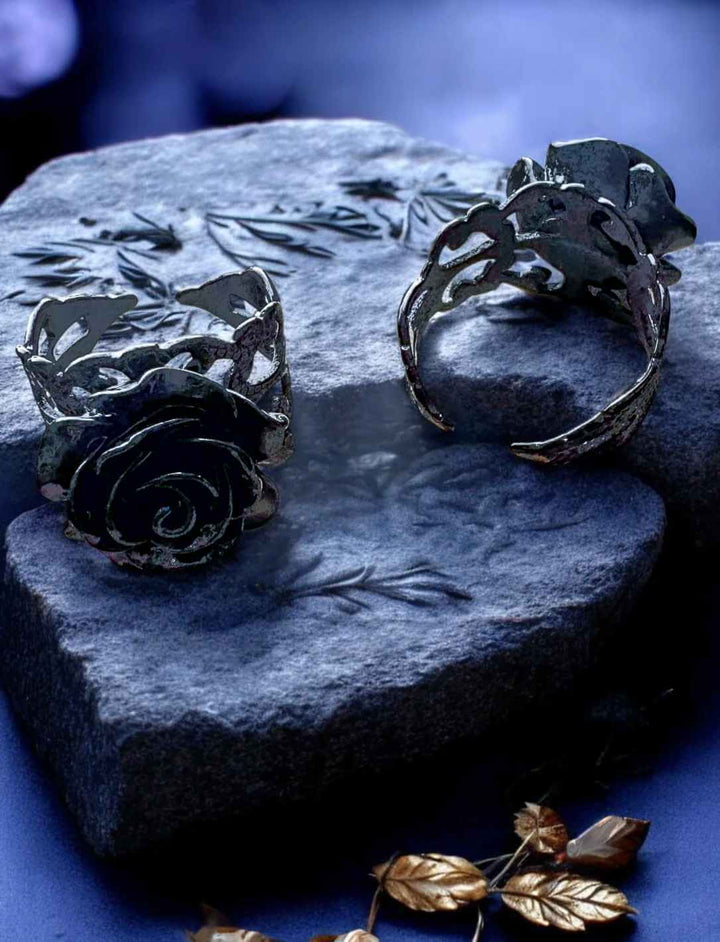 Zwei schwarze Rosenringe aus Edelstahl auf Herzstein – seitliche Ansicht mit detailreicher Ringschiene