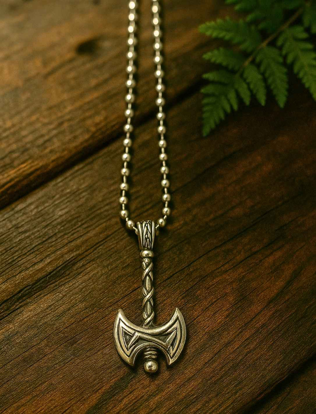 Beidseitiger Axt-Anhänger aus Edelstahl an  Edelstahl Kugelkette auf Holztisch.