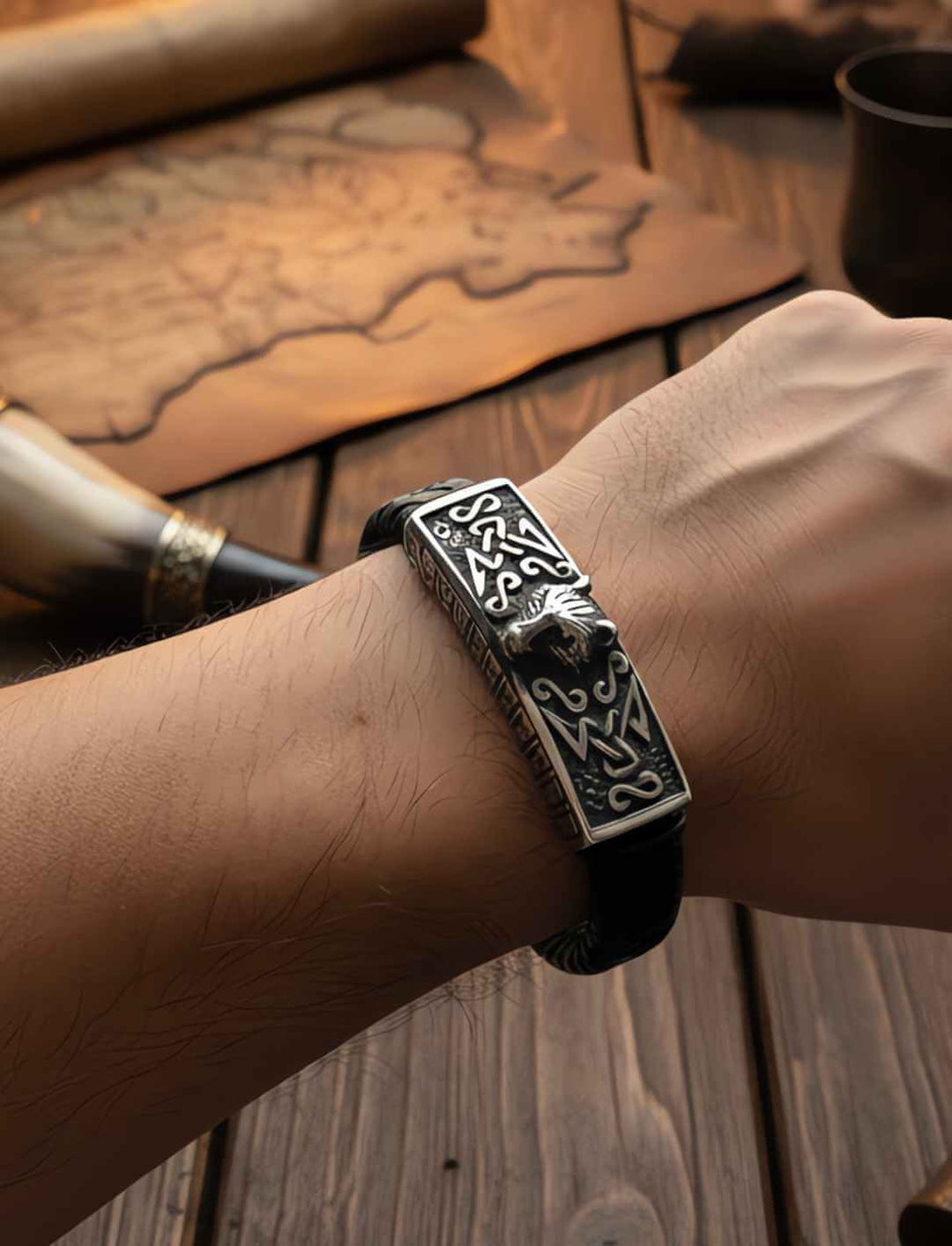Lederarmband Fenrir’s Erbe mit Wolfskopf-Motiv aus Edelstahl auf geflochtenem Leder an Männerarm.