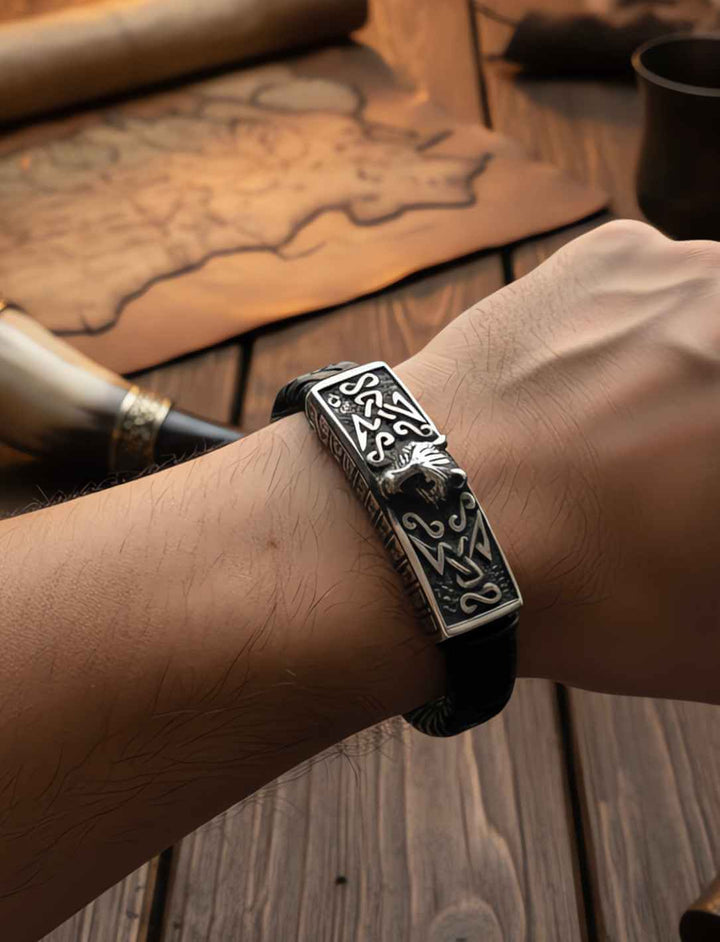 Lederarmband Fenrir’s Erbe mit Wolfskopf-Motiv aus Edelstahl auf geflochtenem Leder an Männerarm.