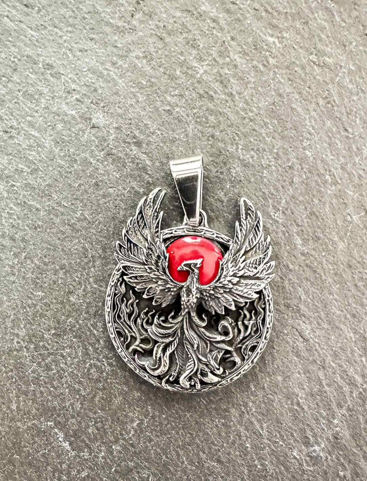 Detailaufnahme des Phönix-Amuletts auf Stein – kunstvoll graviertes Feuervogel-Design