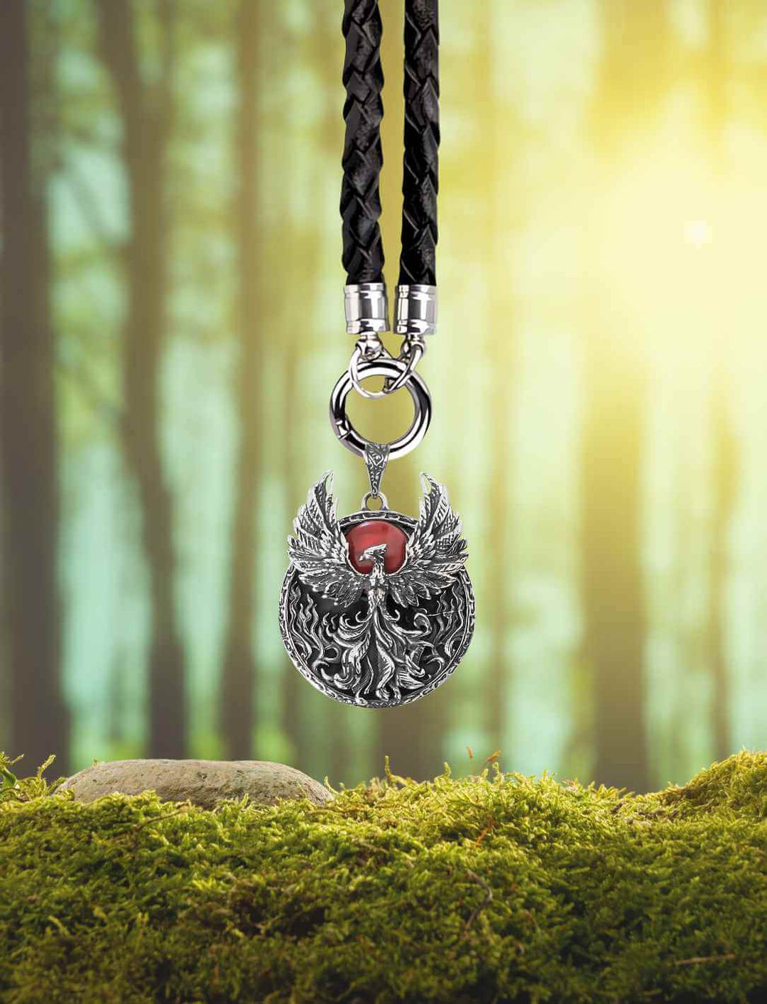 Amulett des Phönix mit geflochtener Lederkette vor Waldboden – Symbolträchtiges Schmuckstück im Fantasy-Stil