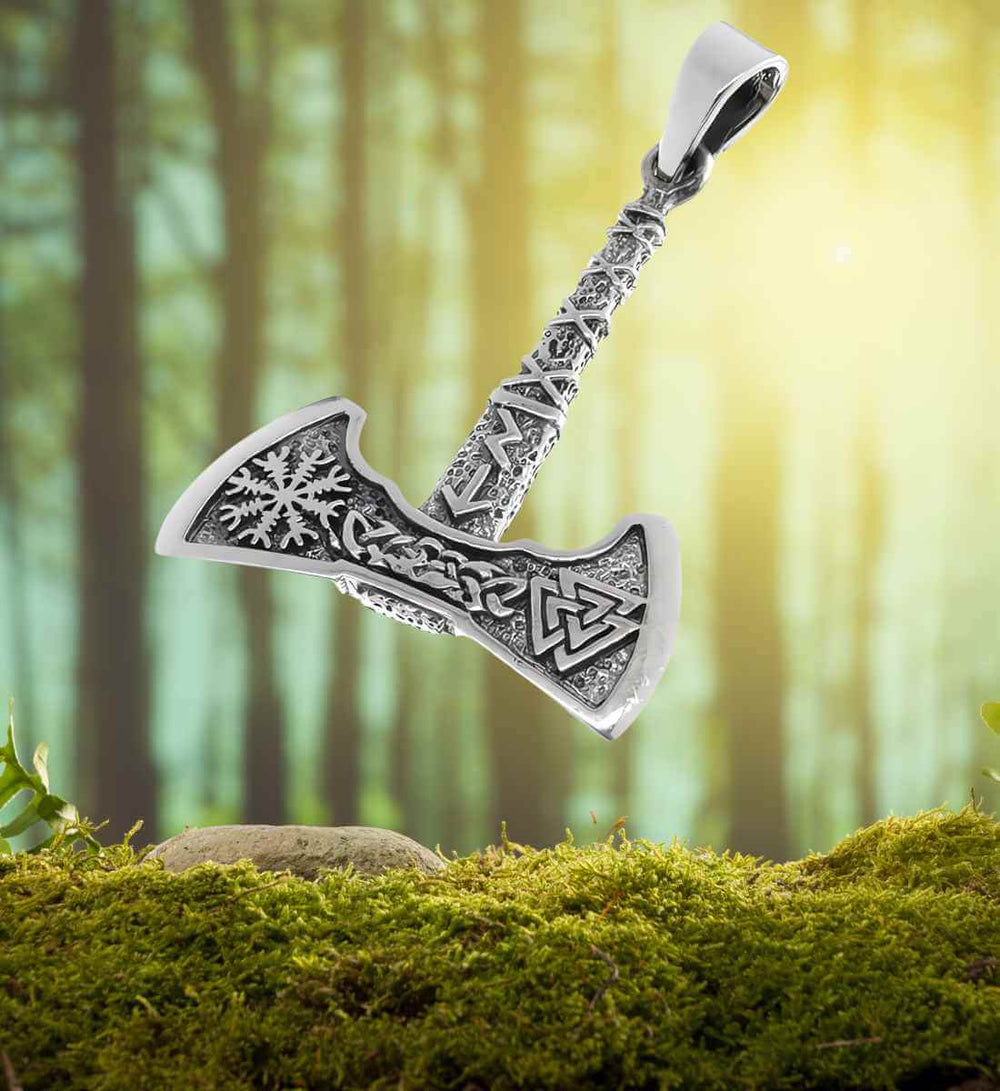 Frostaxt von Thrymheim – Der 925 Sterling Silber Anhänger liegt auf einem Moos- und Waldhintergrund und verbindet so das handwerkliche Geschick der Wikinger mit der wilden Natur Skandinaviens, die den Geist von Thrymheims eisiger Festung einfängt
