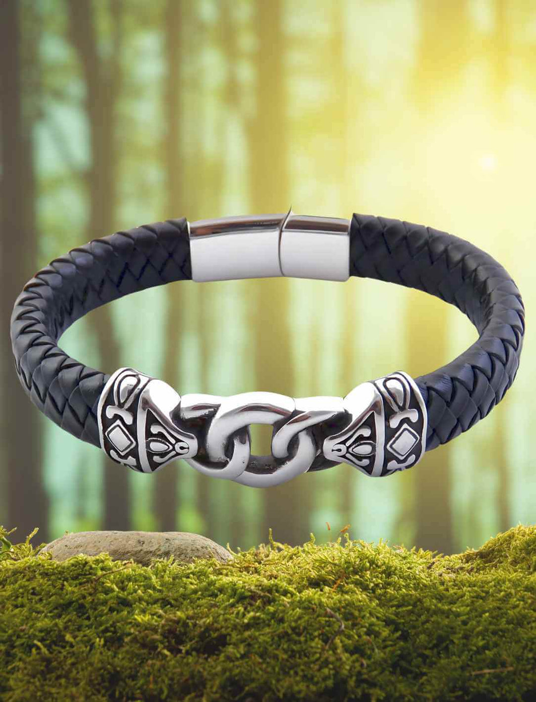 Geflochtenes Lederarmband mit Edelstahl-Gliedern, inspiriert von nordischer Mythologie, auf Moos im Wald liegend