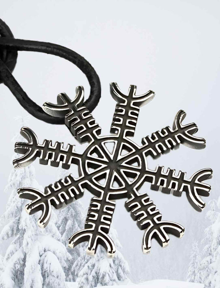 Anhänger ‘Helm der Awe’ aus Edelstahl, mit dem Ægishjálmur-Symbol, elegant präsentiert in einer Schneelandschaft – inspiriert von der kargen nordischen Natur und der mystischen Kraft der Wikinger.