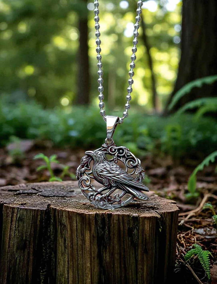 Anhänger Hugins Ruf mit klassischer silberfarbener Edelstahlkette auf Baumstamm