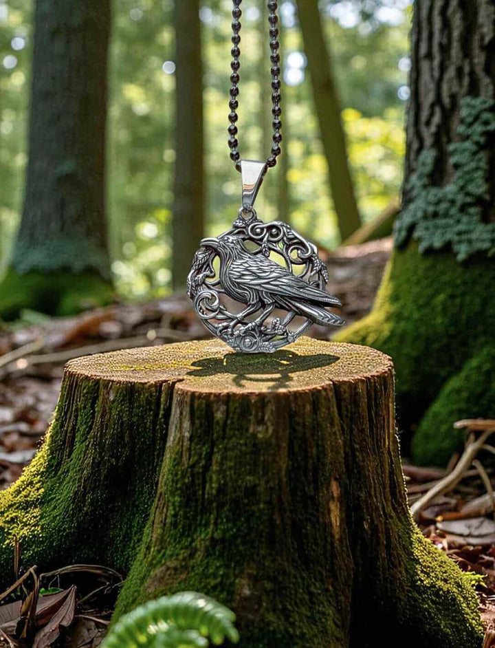 Hugins Ruf Rabensymbol mit schwarzer Edelstahlkette – mystisches Waldfoto auf Baumstumpf