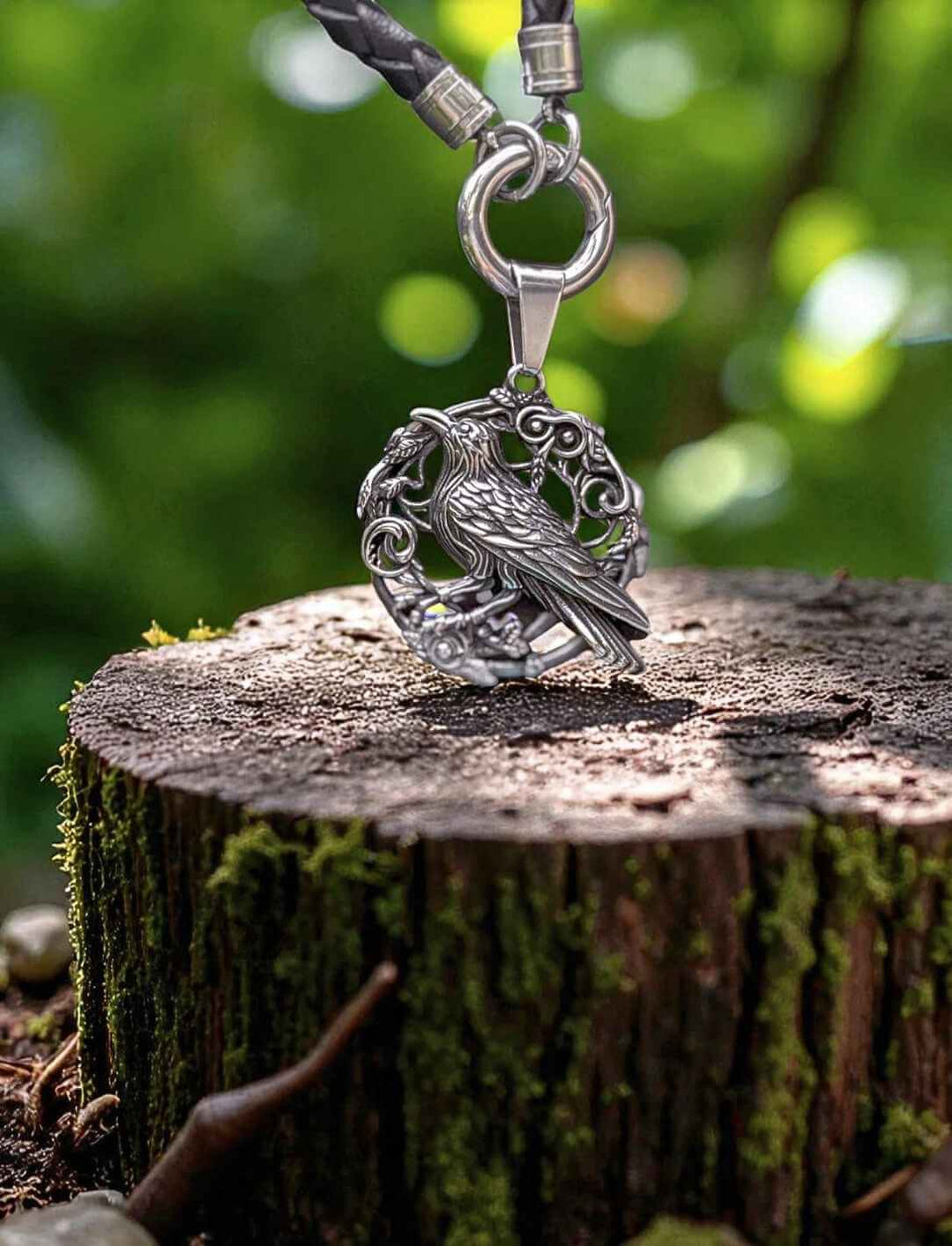 Hugins Ruf Rabenanhänger an gedrehter Lederkette mit Öffnungsclip – fotografiert auf Baumstumpf