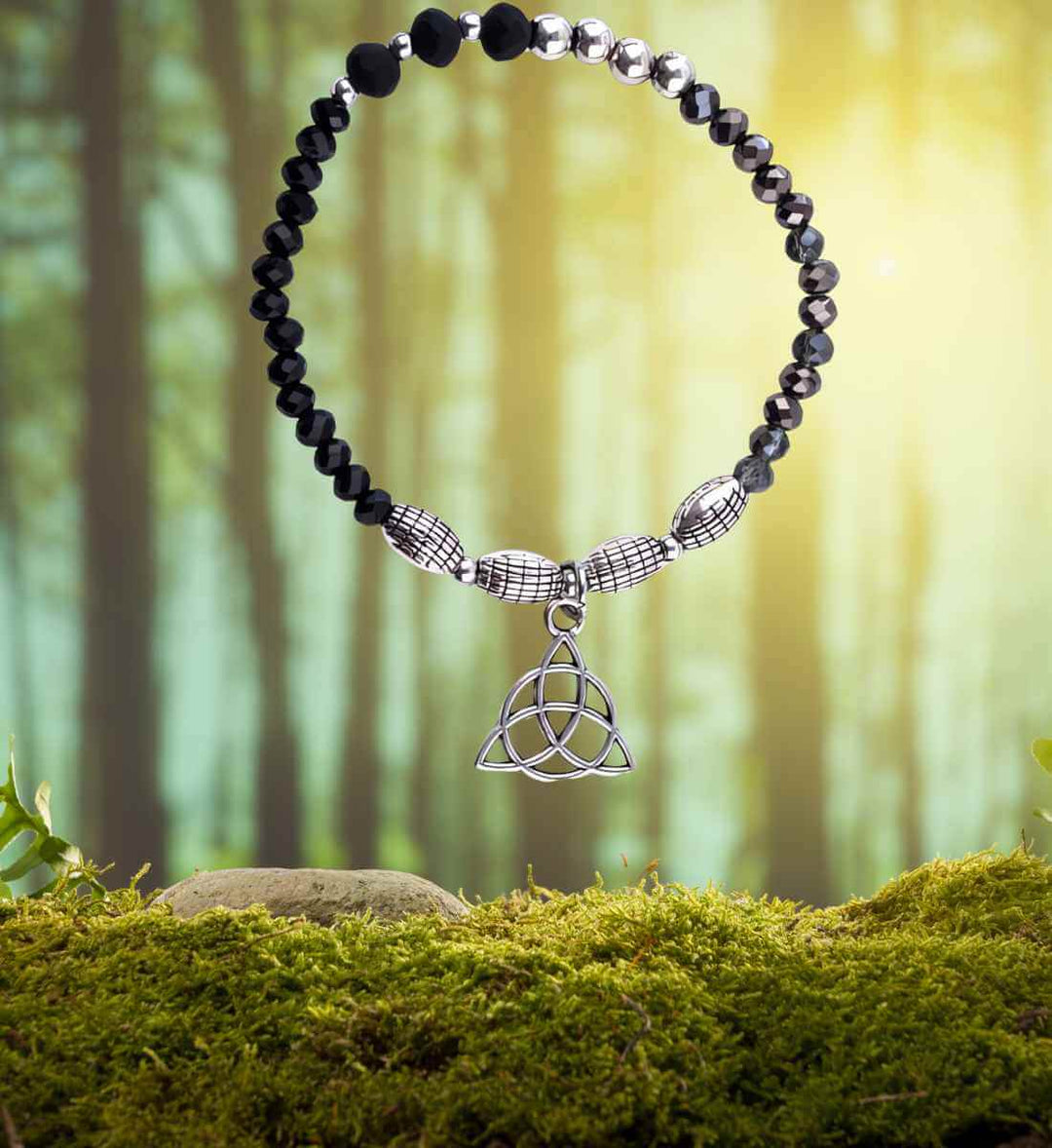 Armband des ewigen Knotens, präsentiert in seiner natürlichen Pracht auf einem Moos- und Waldhintergrund, symbolisiert die tiefe Verbindung zur Erde.