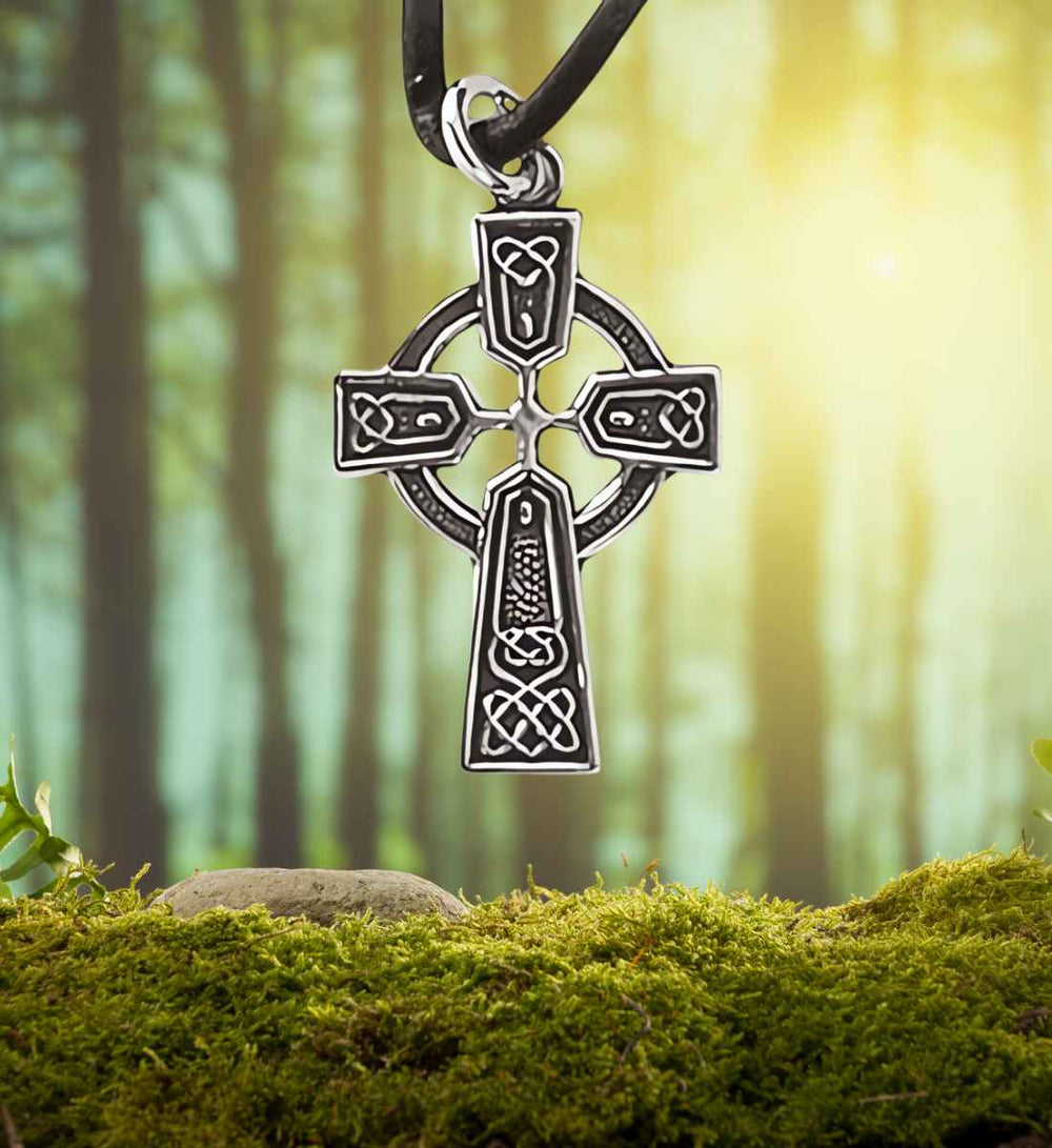  Keltisches Kreuz des Gleichgewichts Anhänger umgeben von der natürlichen Schönheit eines Moos- und Waldhintergrunds.