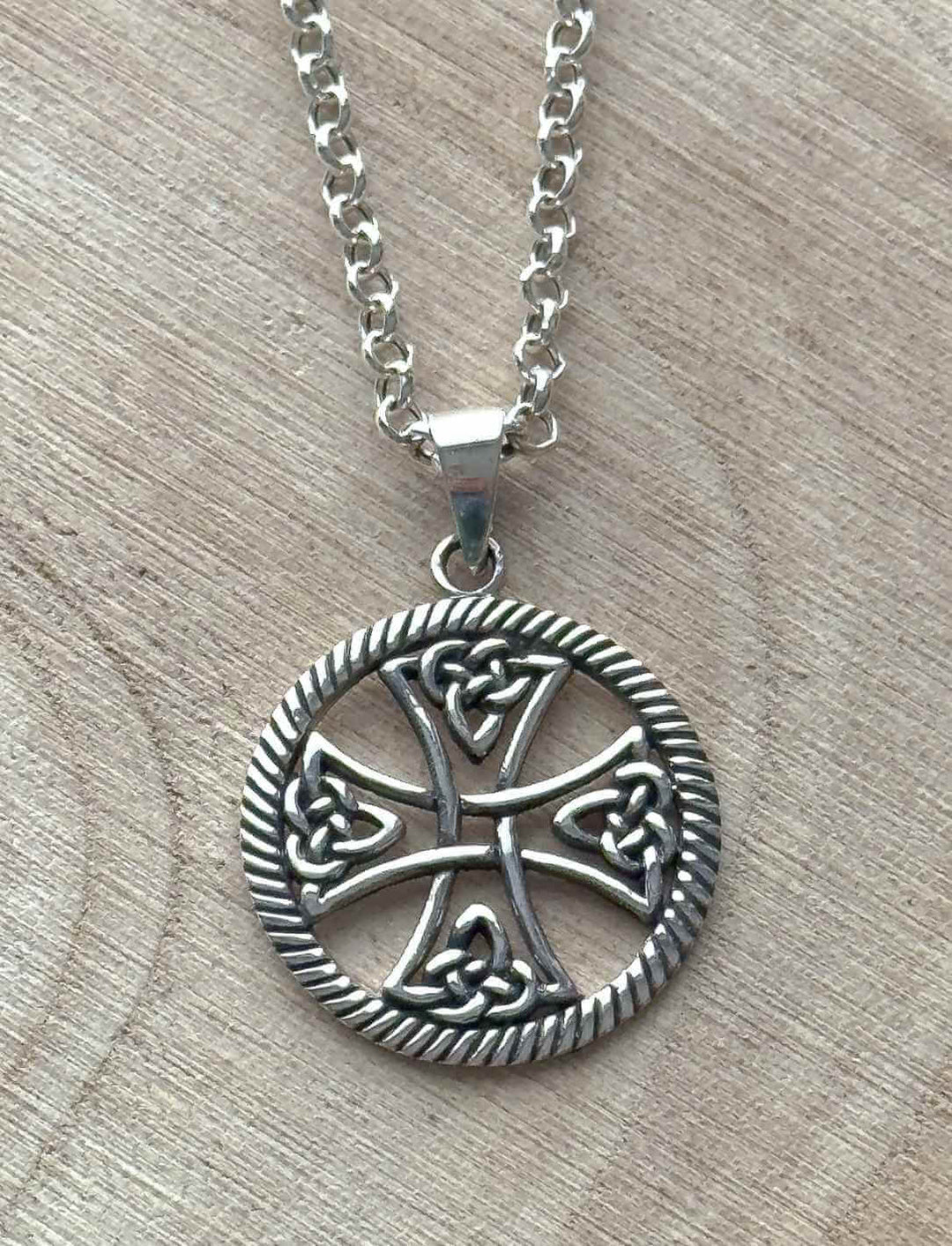 Symbolanhänger Keltisches Lebensrad aus 925er Silber an feiner Anker Gliederkette auf hellem Holz.