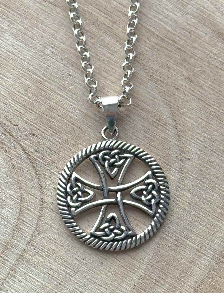 Symbolanhänger Keltisches Lebensrad aus 925er Silber an feiner Anker Gliederkette auf hellem Holz.