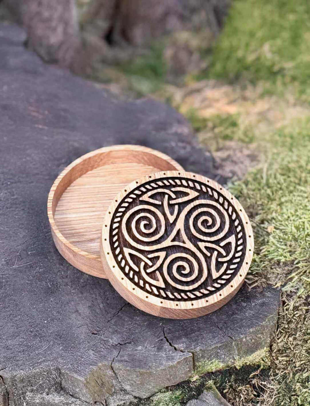 Keltische Triskele-Schatulle aus Eichenholz in natürlicher Umgebung – mystisch inszeniert auf Stein