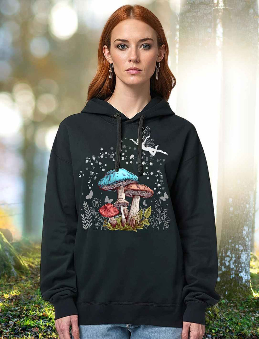Rothaariges Model trägt Magic Mushrooms Hoodie in Schwarz – mystisches Design mit Feen & Pilzen in einem mystischen Märchenwald.