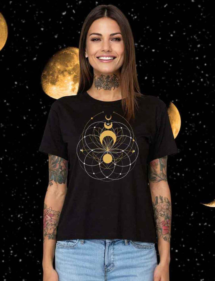 Lächelnde Frau in schwarzem T-Shirt mit 'Mondblüte der Harmonie'-Design, stehend vor Sternen- und Mondhintergrund.