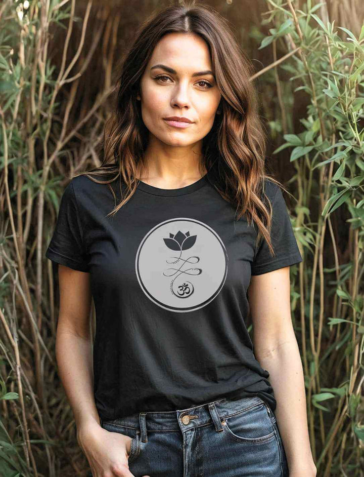 Eine junge Frau im Wald trägt das Om Florales T-Shirt in Schwarz, das die zeitlose Eleganz der Lotusblüte und das Om-Symbol vereint.