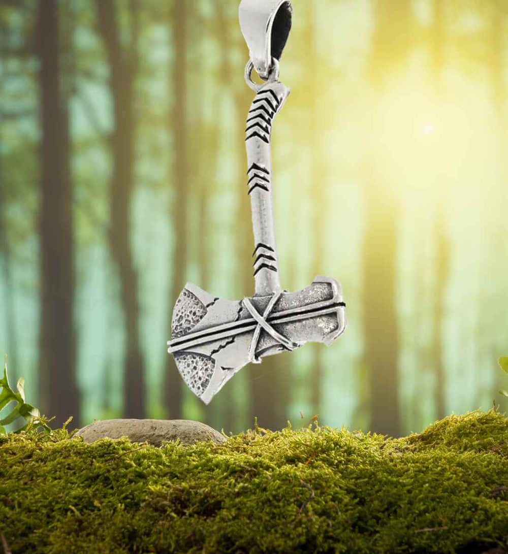Runenaxt des Nordens – Detailreicher 925 Sterling Silber Anhänger in Form einer Wikingeraxt, präsentiert auf einem Wald- und Mooshintergrund.
