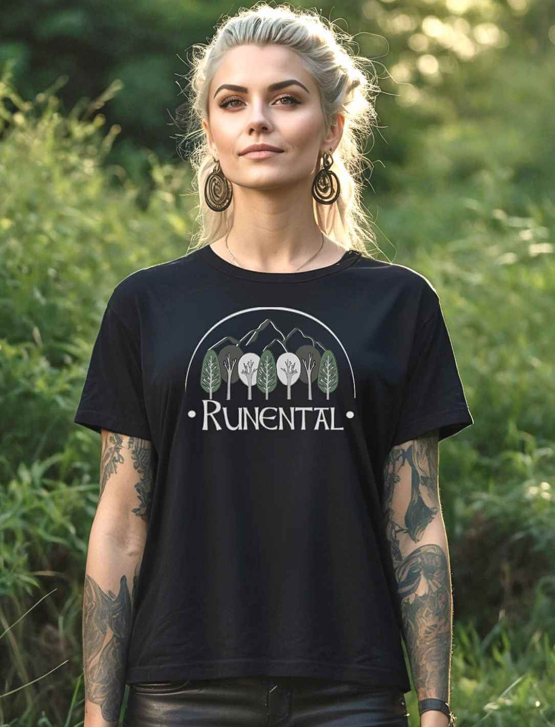 Blonde Frau trägt das schwarze  “Runental Fan-Kollektion” Damen Organic T-Shirt im Wald – Mystisches Design mit Runental-Logo, eingefangen in einer natürlichen Umgebung.