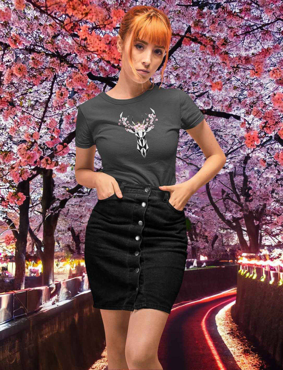 Eine junge Frau in einem anthrazitfarbenen "Sakura Deer" T-Shirt, auf dem ein Hirsch von Sakura umringt ist, das einen modernen Touch zu traditionellen japanischen Motiven gibt.