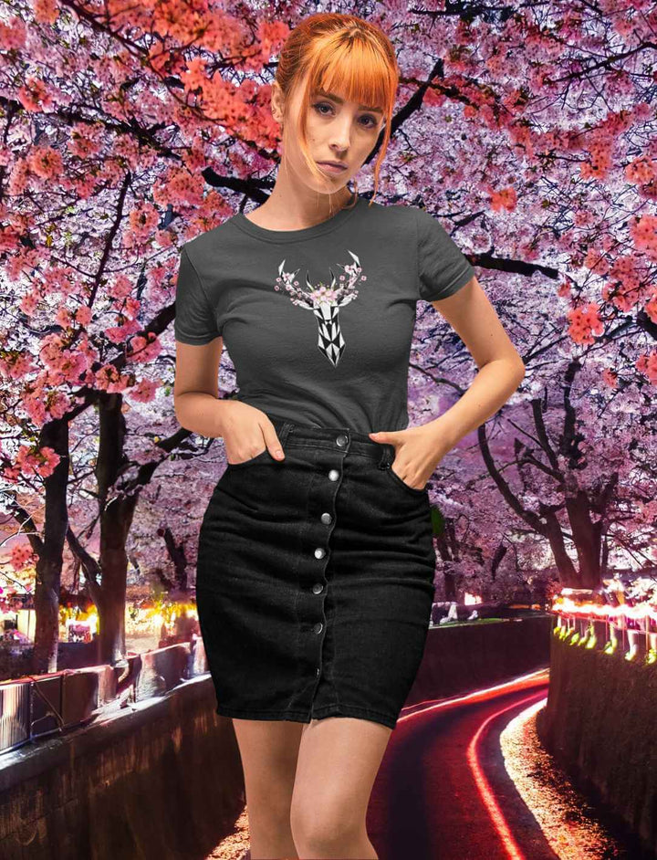 Eine junge Frau in einem anthrazitfarbenen "Sakura Deer" T-Shirt, auf dem ein Hirsch von Sakura umringt ist, das einen modernen Touch zu traditionellen japanischen Motiven gibt.