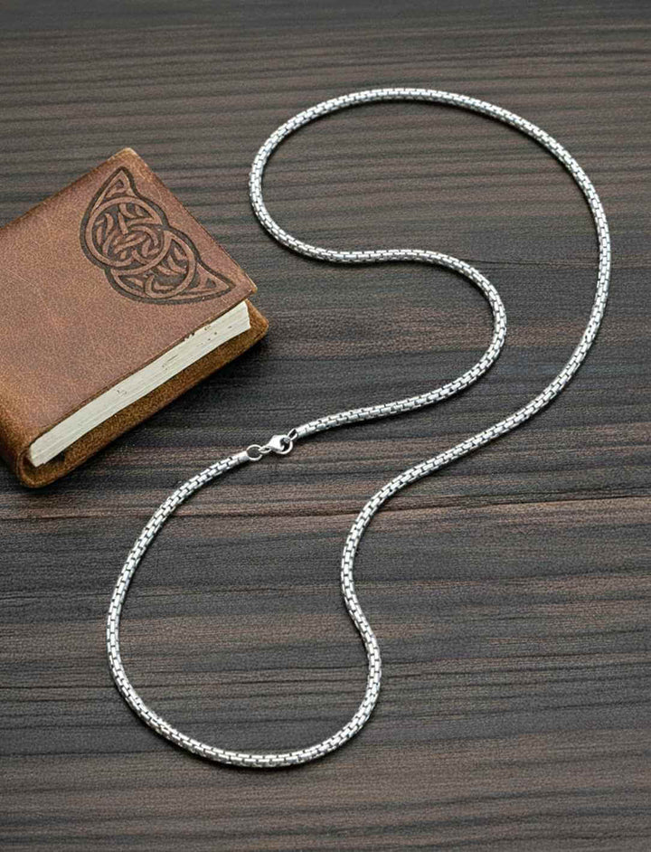 Edelstahl Schlangenkette im keltisch-nordischen Stil auf dunklem Hintergrund