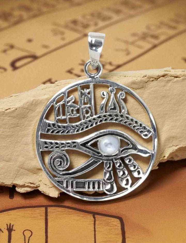 Silberanhänger Auge des Horus mit Mondstein auf antikem Papyrus-Hintergrund fotografiert