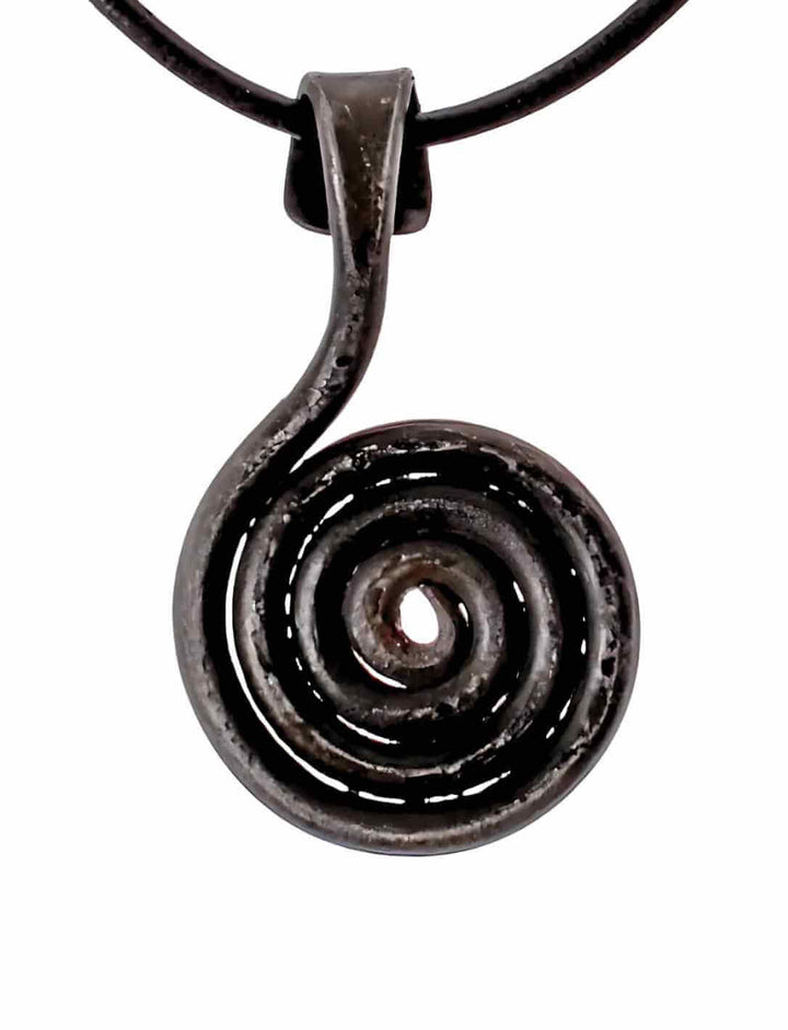 Detailaufnahme des Solsnurra â Sonnenzeichen von Midgard Amuletts, geschmiedet aus Eisen. Die kunstvolle Spirale erinnert an alte Wikingerfunde und trĂ€gt die Kraft der Sonne in sich.