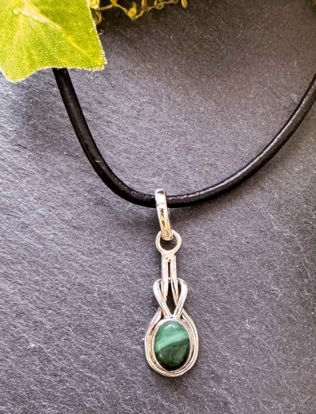 Grüner Malachit-Anhänger in filigraner Silberfassung an schwarzem Band – naturinspirierter Schmuck