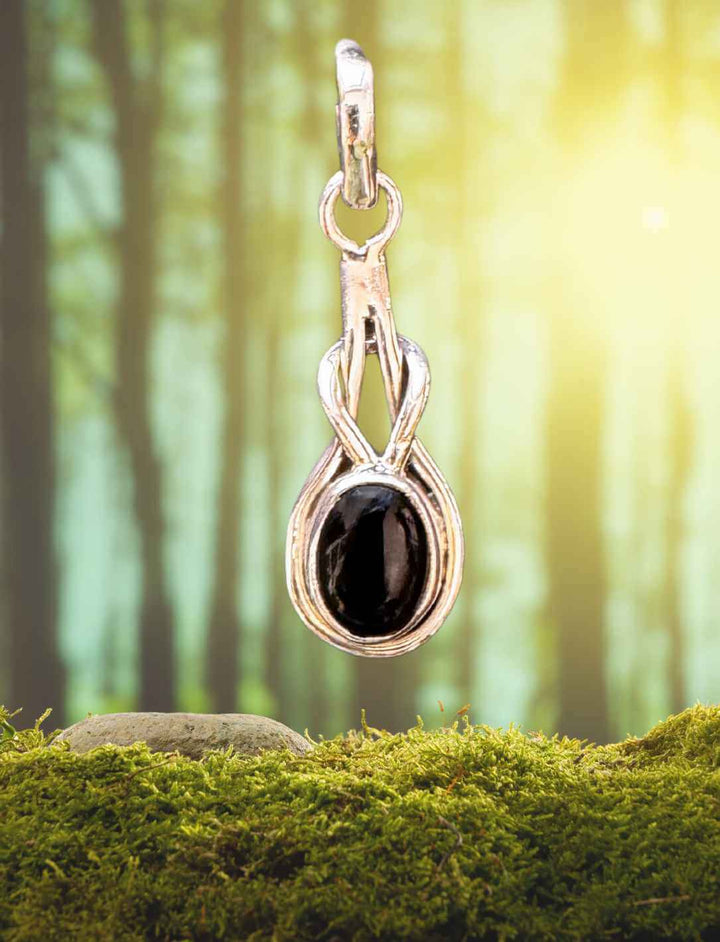 Silberanhänger mit schwarzem Onyx als Träne der Weisheit – stimmungsvoll inszeniert im Waldlicht