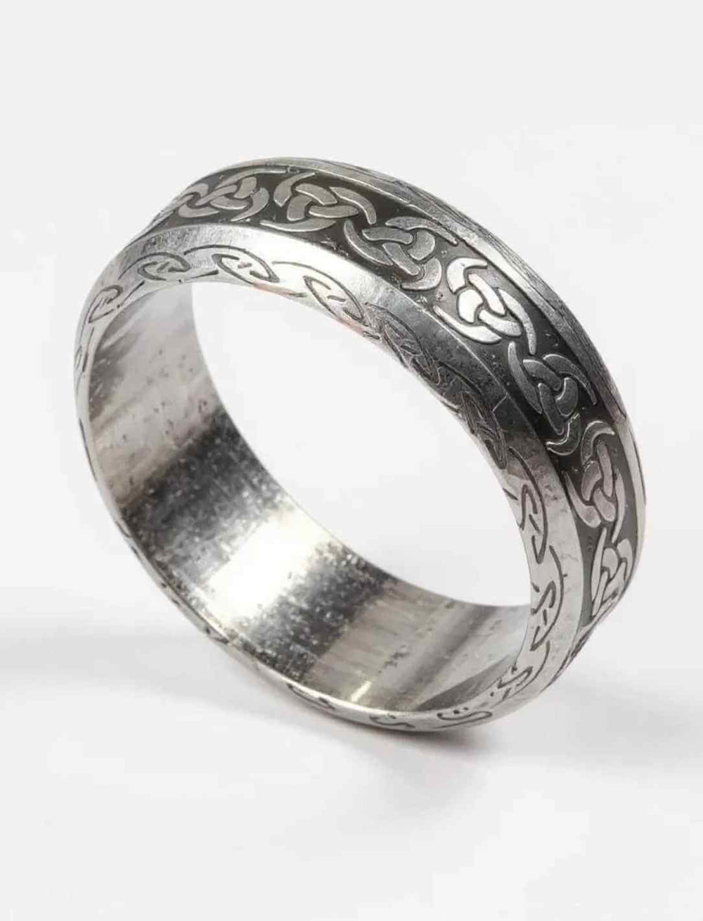 Keltischer Triskele-Ring aus Edelstahl mit antik gebürsteter Oberfläche, schräg fotografiert, Fokus auf Ringform und Innenfläche