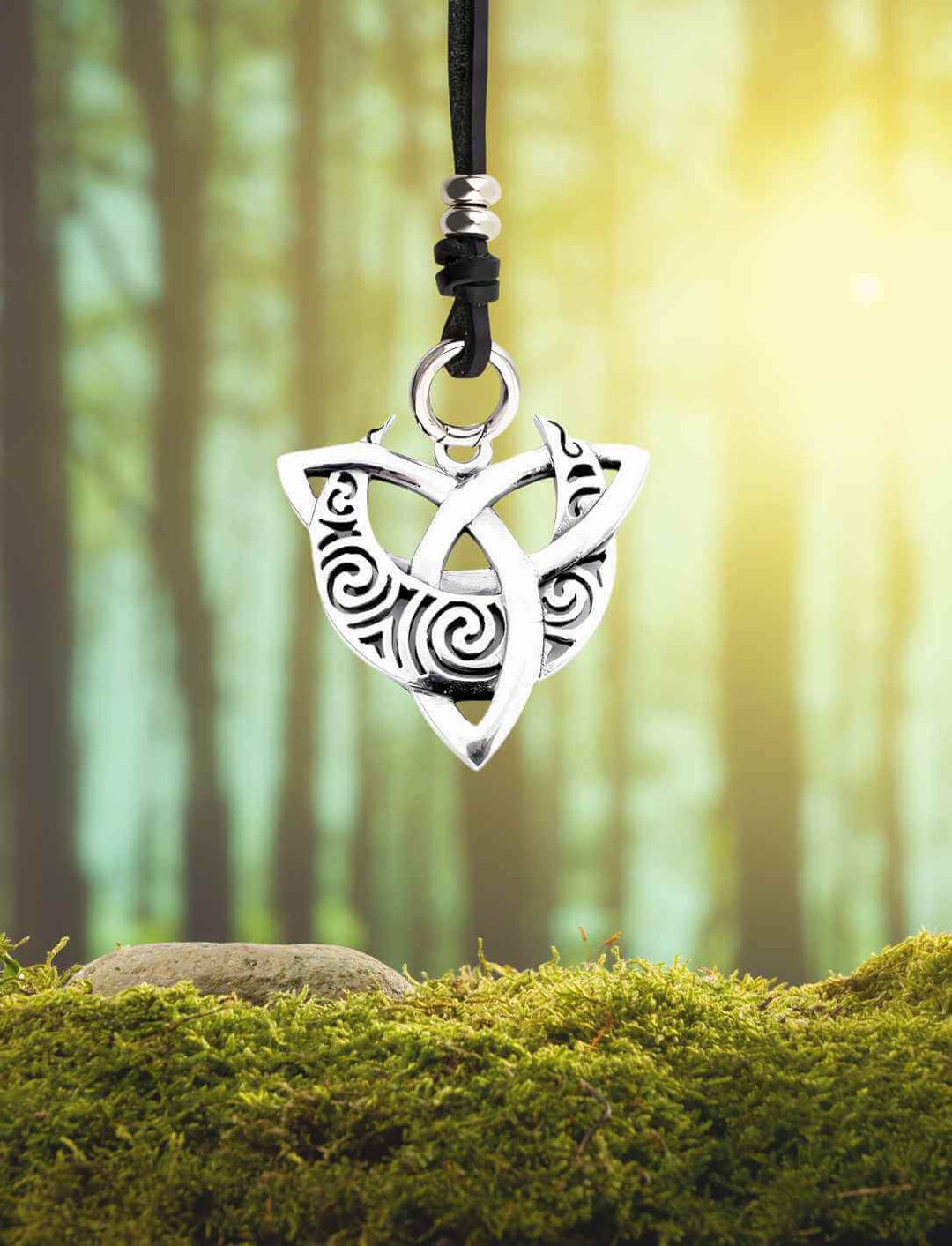 Amulett „Triquetra der Druidin“ – mystischer Silberanhänger mit keltischem Knotenmuster, inszeniert vor magischer Waldkulisse mit Lederband des Waldläufers.