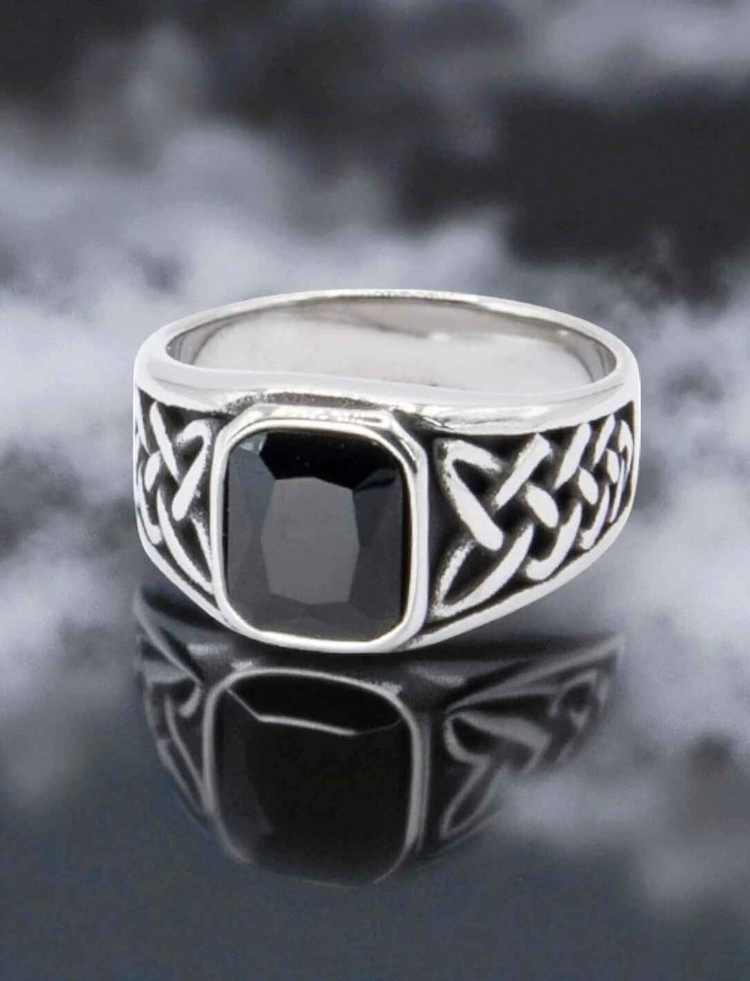 Keltischer Siegelring mit schwarzem Zirkonia und Knotenmuster auf dunklem Hintergrund