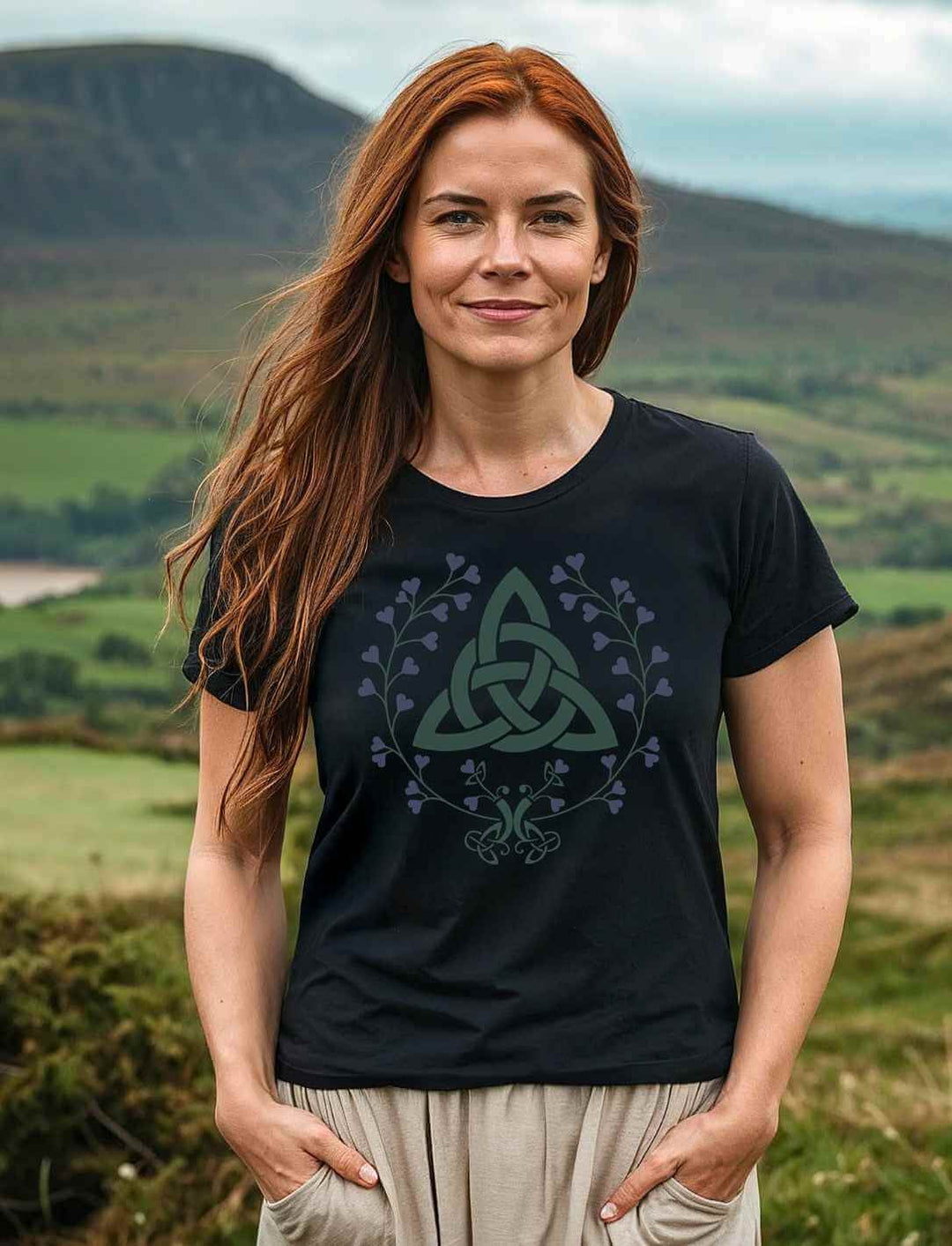 Frau trägt das Triquetra des grünen Bundes Damen Bio-Shirt vor keltischer Landschaft