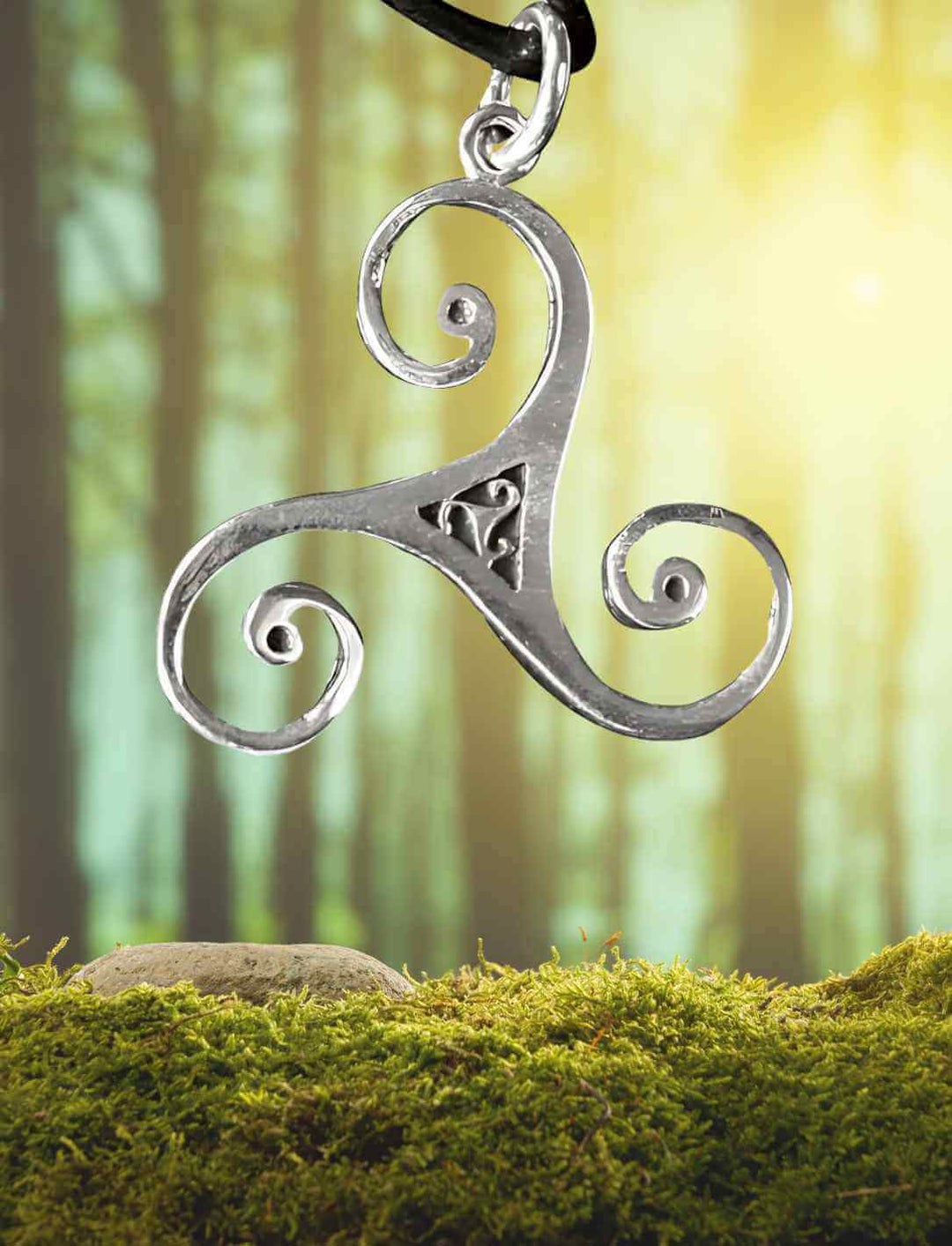 riskele-Anhänger aus 925 Sterling Silber mit keltischem Muster, präsentiert in einer mystischen Waldkulisse.