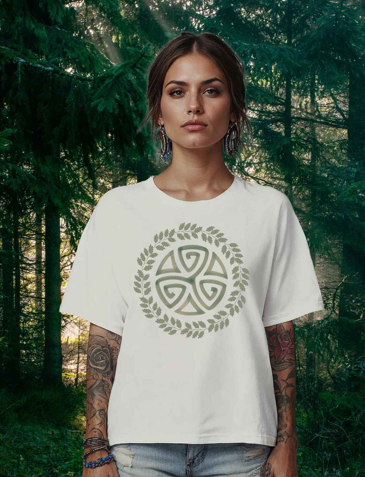 Model im weißen “Triskele des Waldes” Damen Organic Shirt mit keltischem Symbol vor Waldkulisse