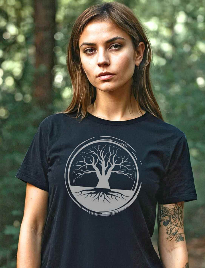 Junge Frau rägt das „Uralte Wurzeln“ Damen T-Shirt in einem natürlichen Waldumfeld, was die tiefe Verbundenheit mit der Natur unterstreicht.