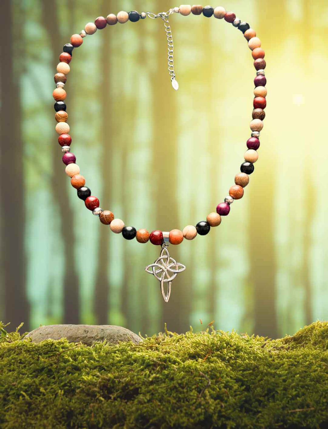 Keltische Perlenkette „Wächterin des Hains“ auf Moos – handgefertigtes Unikat aus Holzperlen und Edelstahlkreuz, fotografiert im mystischen Morgenlicht des Waldes.