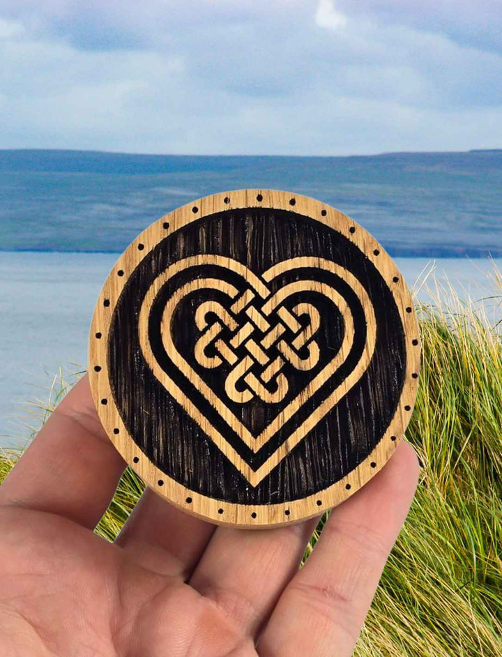 Celtic Heart Schmuckdose in Hand vor Küstenhintergrund gehalten