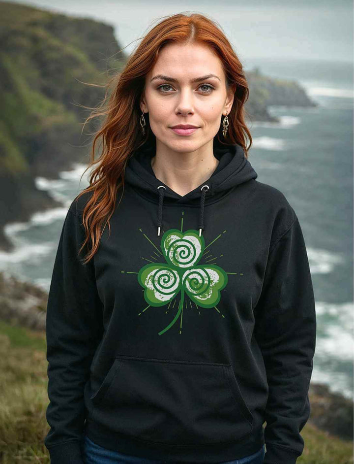 Frau trägt den Trifolia Mystica Hoodie in Schwarz vor dramatischer irischer Küstenlandschaft – stilvoll & mystisch zugleich.