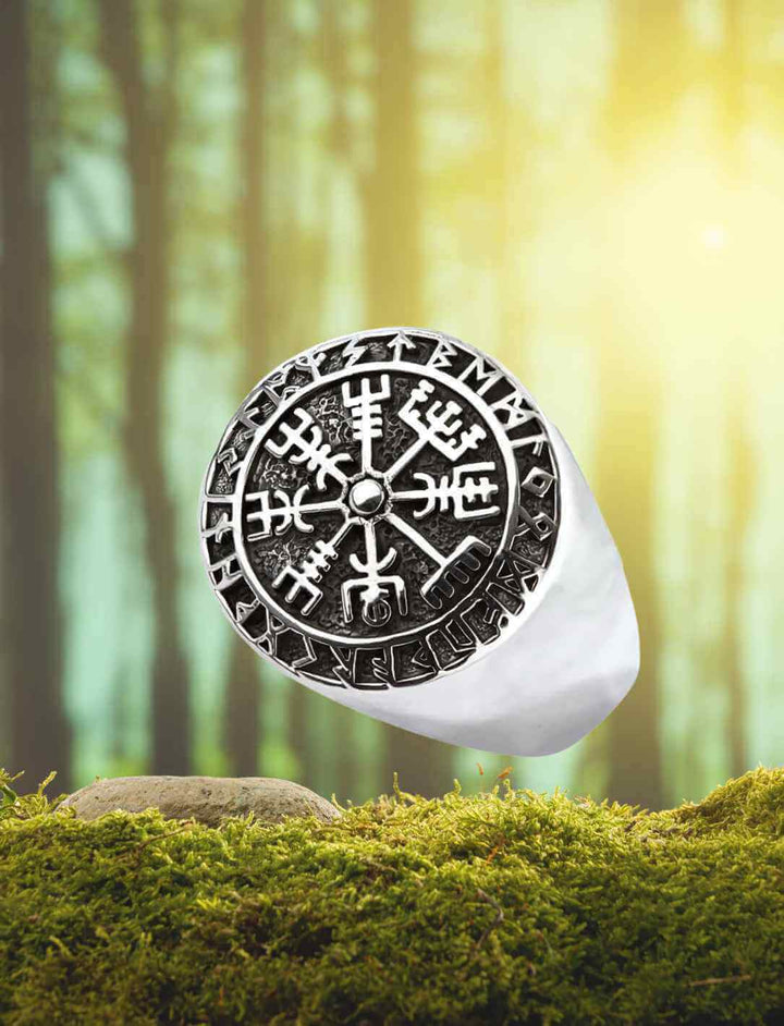 Vegvísir Silberring – Wikinger-Kompass mit Runen, präsentiert auf einem Moosbett vor einem mystischen Waldhintergrund.